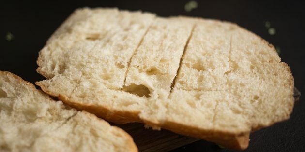 Comment faire des croûtons au fromage à l'ail: couper un pain en deux