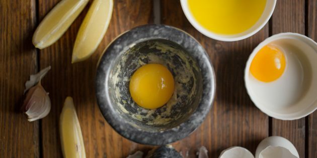 Comment faire cuire les pleurotes dans une pâte avec de l'aïoli: frottez l'ail avec les jaunes et le sel
