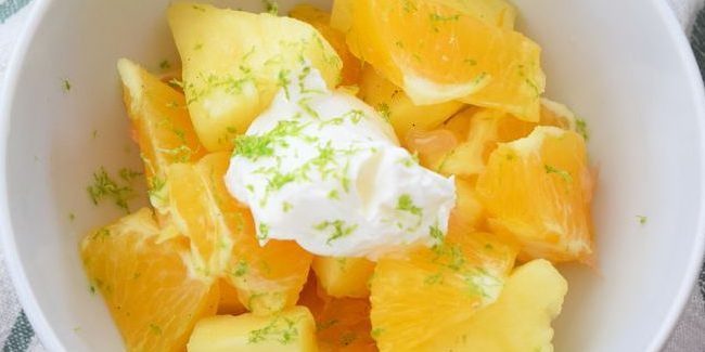 C salade de fruits avec des oranges, ananas et sauce à la vanille