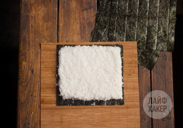 Comment faire un sushirrito: Placez une feuille de nori sur un tapis et recouvrez-la d'une couche de riz