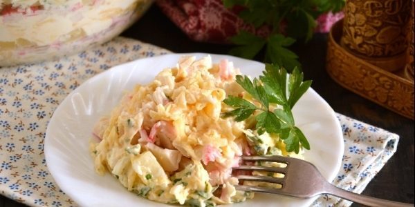 Comment préparer une salade à l'ananas, les bâtonnets de crabe, les œufs et le fromage