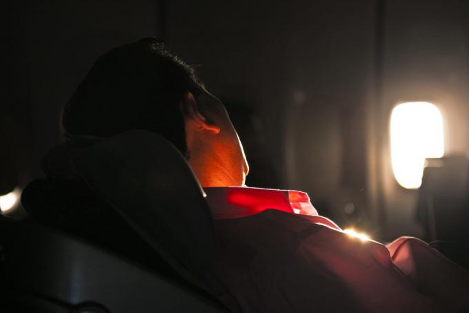 homme qui dort dans le siège d'un avion dans le lever du soleil