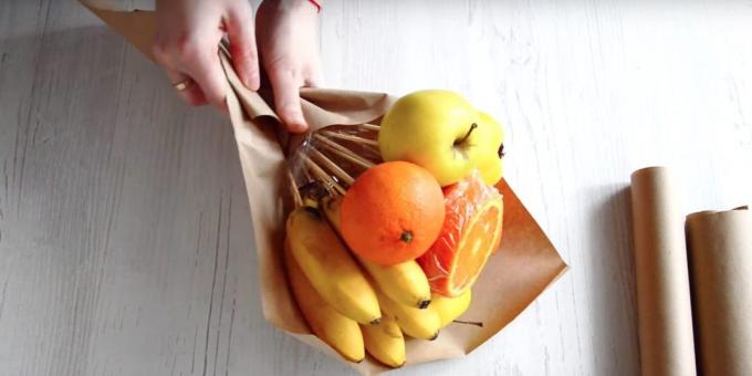 Mettez un tas de fruits avec vos mains en diagonale à travers le papier et envelopper le fond